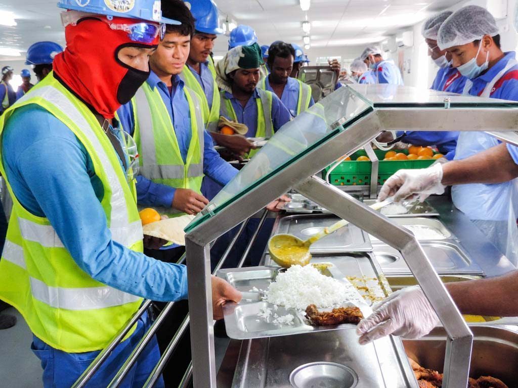 Construction workers eat at Khalifa Stadium