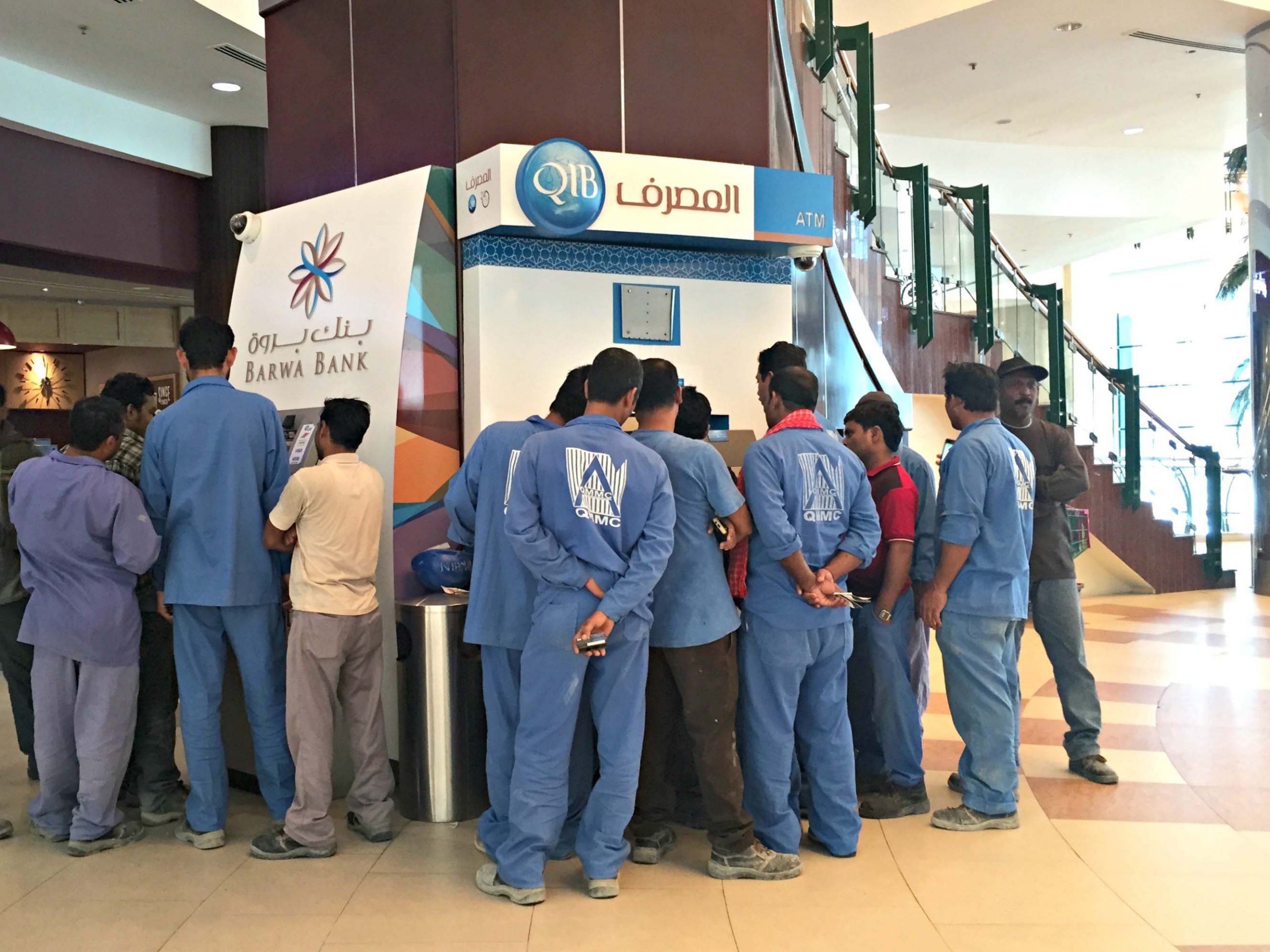 More than a dozen men wait to use the ATMs at City Center Mall.